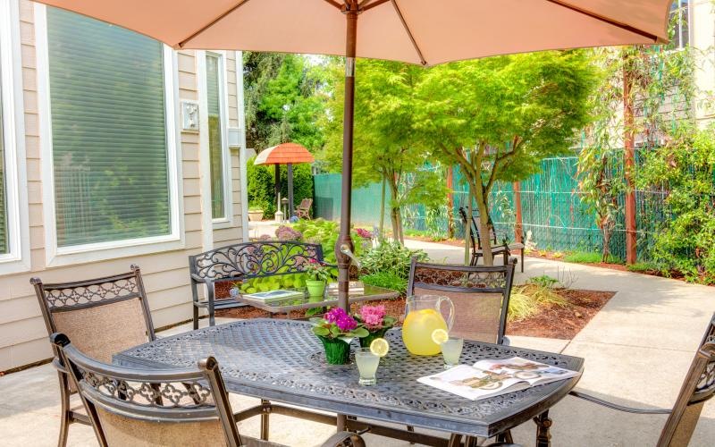 a patio with a table and chairs and umbrellas